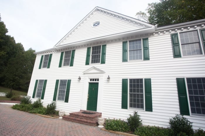 2-story home painted white with green shutters